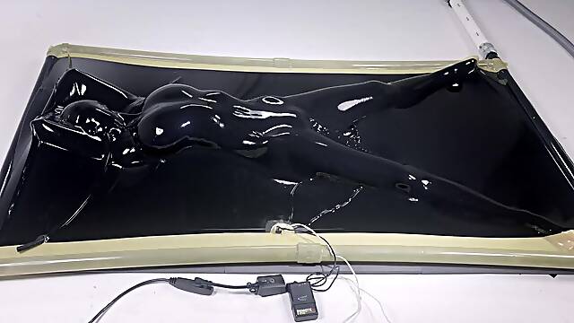 Latex vacbed climax with dildo and e-stim